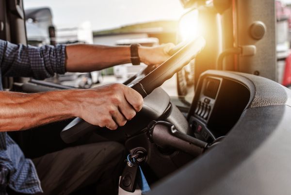 Driver's hands on the wheel of a tractor unit